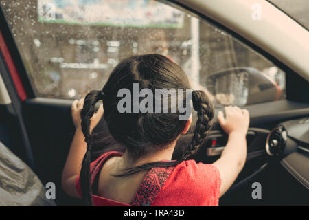 Mädchen sitzen im Auto auf den Regen, vintage Bild, Stockfoto