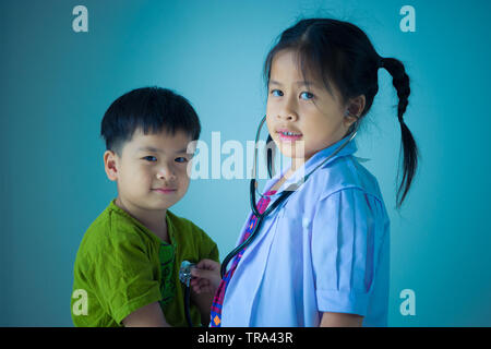 Asiatische niedliche Kinder spielen als Arzt und Patient Stockfoto