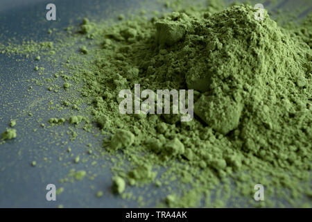 Close up Haufen von Matcha Pulver auf schwarzem Teller. Natürliche Matcha Grüntee Konzept. Stockfoto