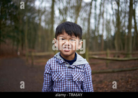 Adorable kleine asiatische Junge mit großen braunen Augen in einem Park im Herbst Stockfoto