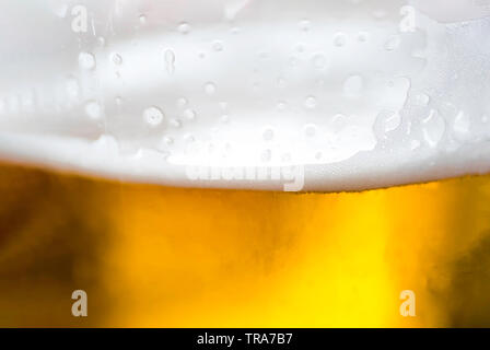 Makroaufnahme von Bier im Glas Hintergrund - Bier mit Schaum extreme Nahaufnahme Hintergrund Stockfoto