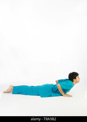 Porträt EINES JUNGEN DURCHFÜHRUNG DER SURYA NAMASKAR POSE #7 namens Kobra (Bhujangasana) Stockfoto