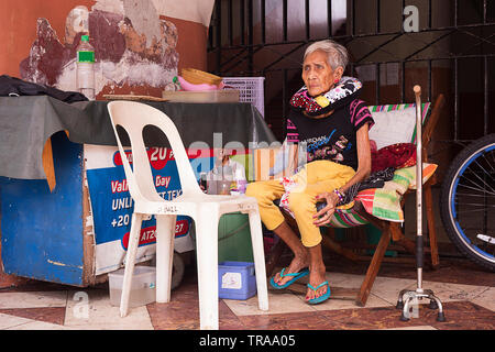 Manila, Philippinen - Dezember 21, 2016: Obdachlose ältere Frau, die alleine auf der Straße Stockfoto