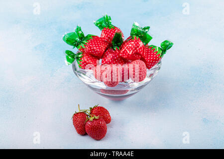 Erdbeere Süßigkeiten und Strawberry flavored candy Konzept mit Nahaufnahme auf süß und sauer Rot sauer Gürtel in Zucker isoliert auf einem hölzernen backgrou abgedeckt Stockfoto