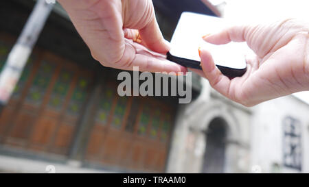 Hand, schwarz Telefon suchen Informationen zu unscharfen Hintergrund, Low Angle selektiven Fokus Stockfoto