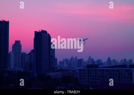 Drohne fliegen in Abend Himmel über die Wolkenkratzer von Bangkoks Suburban, Thailand Stockfoto
