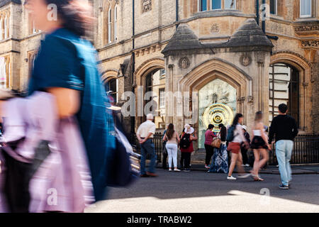 Touristen in Cambridge Foto und vorbei an den Die Taylor Bibliothek und das Corpus Clock an der nordwestlichen Ecke von Corpus Christi College. Stockfoto