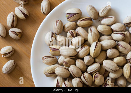 Pistazien in einer weißen Untertasse container Platte fertig bedient und gegessen werden. Stockfoto