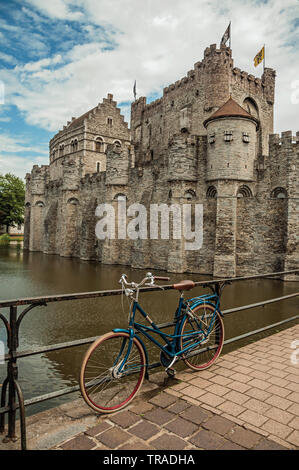 Brücke und Fahrrad vor der Burg Gravensteen an bewölkten Tag in Gent. Stadt mit intensiven kulturellen Lebens und gotischen Gebäuden in Belgien. Stockfoto