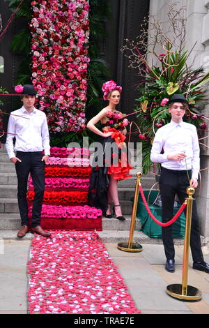 Von Manchester King Street Festival und Flower Show eröffnet für zwei Tage am 1. Juni 2019, Performance, Musik und kreative Blumenarrangements. Das Festival ist zu einem Retro 60er's Theme. Zwei Männer und eine Frau Modell eine florale suchen. Stockfoto