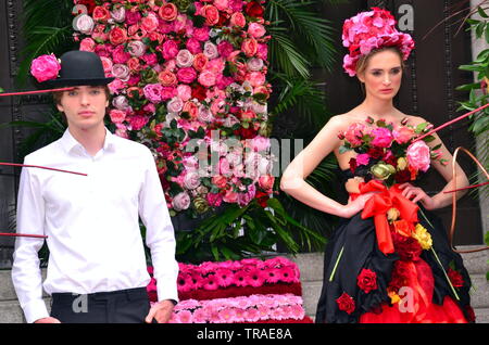 Von Manchester King Street Festival und Flower Show eröffnet für zwei Tage am 1. Juni 2019, Performance, Musik und kreative Blumenarrangements. Das Festival ist zu einem Retro 60er's Theme. Ein Mann und eine Frau Modell eine florale suchen. Stockfoto