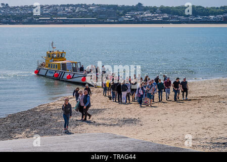 Die Padstow zu Rock Passagierfähre aussteigen auf Rock Beach mit zahlreichen Passagieren an einem sonnigen Tag. Cornwall UK. Stockfoto