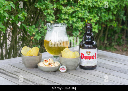 Sint Gillis Waas, Belgien - 22 Juli 2018: Belgisches Bier Duvel mit Feta und gesalzene Chips in Sint Gillis Waas, Belgien. Stockfoto