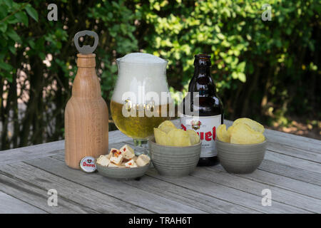 Sint Gillis Waas, Belgien - 22 Juli 2018: Duvel, Belgien Bier Feta Käse und gesalzene Chips und eine hölzerne Flaschenöffner in Form einer Flasche duve Stockfoto