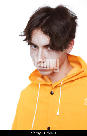 Porträt einer jugendlich Kerl in einem gelben Regenmantel brunette im Studio. Stockfoto