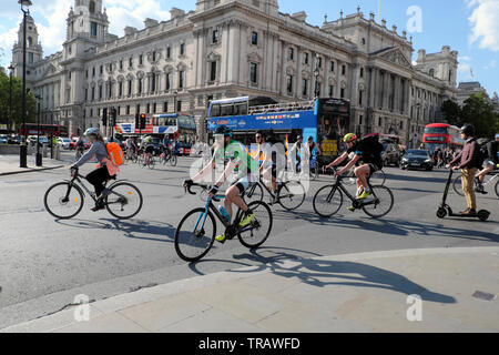 Radfahrer Büro nach Hause nach der Arbeit Reiten Bikes von Häusern des Parlaments & Touristenbusse auf verkehrsreichen Straße, Westminster London UK KATHY DEWITT Stockfoto