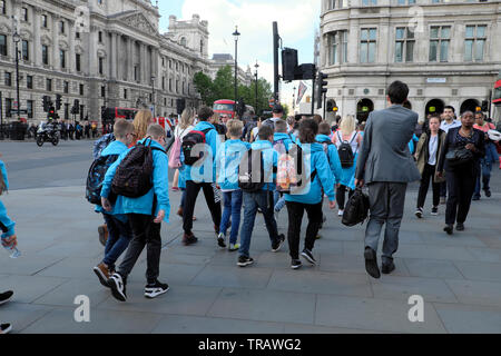 Rückansicht Grundschule Schüler in Uniform auf Schulausflug Tour Am Houses of Parliament Square und Fußgängern, die West London zu Fuß erreichen SW1 UK KATHY DEWITT Stockfoto