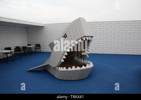 Große, graue geöffnet shark Maul mit Zähnen Kinder Spielzeug mit blauem Teppich auf dem Dach von Lego Haus Billund, Dänemark 2017 Stockfoto