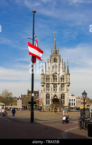 Gouda, Holland, Niederlande, April 23, 2019 - mittelalterliche gotische Rathaus im Zentrum der Altstadt Platz der Gauda, einige in der Nähe Aussicht auf Gebäude mit t Stockfoto