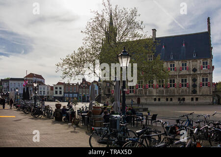 Gouda, Holland, Niederlande, April 23, 2019 - mittelalterliche gotische Rathaus im Zentrum der Altstadt Platz der Gauda, einige in der Nähe Aussicht auf Gebäude mit t Stockfoto