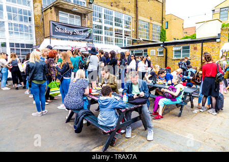 27. Mai 2019 Menschen im Hinterhof des Kesselhauses Essen im Freien von Festival, London, UK sitzen Stockfoto