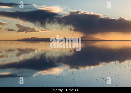 Farbenfroher Sonnenuntergang Wolken auf dem Salar de Uyuni, Bolivien, während der nassen Jahreszeit wider Stockfoto