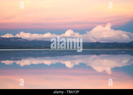 Farbenfroher Sonnenuntergang Wolken auf dem Salar de Uyuni, Bolivien, während der nassen Jahreszeit wider Stockfoto