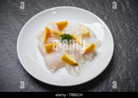 Frisches rohes Fischfilet Stück mit Zitrone auf weiße Platte/Close up Pangasius dolly Fisch Fleisch Stockfoto