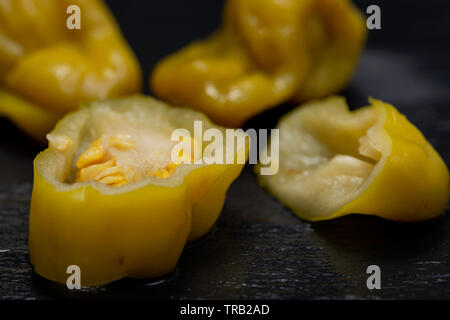 Gebeizt Golden griechische Paprika, pepperoncini oder Friggitelli (süßen italienischen Chili) auf Naturstein Hintergrund. Capsicum annuum. Stockfoto