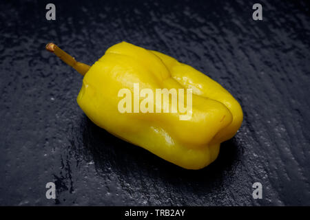Gebeizt Golden griechische Paprika, pepperoncini oder Friggitelli (süßen italienischen Chili) auf Naturstein Hintergrund. Capsicum annuum. Stockfoto