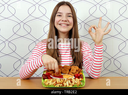 Happy Teenager mit leckeren Chicken Nuggets und ok Handzeichen Stockfoto