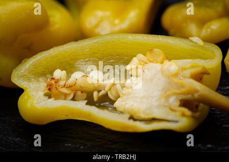 Gebeizt Golden griechische Paprika, pepperoncini oder Friggitelli (süßen italienischen Chili) auf Naturstein Hintergrund. Capsicum annuum. Stockfoto
