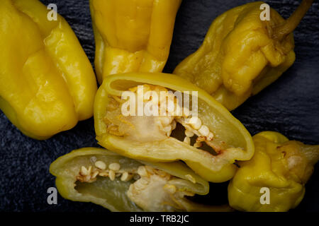 Gebeizt Golden griechische Paprika, pepperoncini oder Friggitelli (süßen italienischen Chili) auf Naturstein Hintergrund. Capsicum annuum. Stockfoto