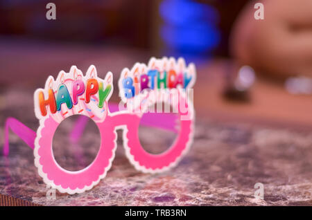 Rosa Brille/Specs aus Pappe/Papier mit Happy birthday nach oben geschrieben. Stockfoto