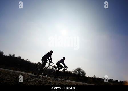 Radfahrer vorbei an einer wunderschönen kleinen Pfad in der Natur in einem weiten, offenen Landschaft genießen das Wetter und die Schönheit um Sie herum Stockfoto