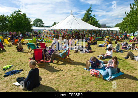 Besucher entspannt auf dem Rasen an Hay Festival Heu Wye Powys Wales UK Stockfoto