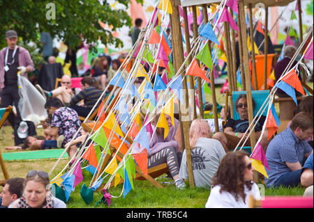 Besucher entspannen im Festzelt auf dem Rasen im Garten während Hay Festival Heu Wye Powys Wales UK Stockfoto