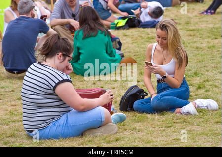 Junge Frauen Entspannen auf dem Rasen an Hay Festival Heu Wye Powys Wales UK Stockfoto