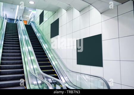 Öffentliche Rolltreppe mit leeren Plakat an der Wand in der Nähe der U-Bahn Stockfoto