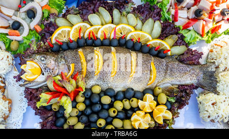 Gegrillte Forelle, Karpfen und Meeräsche. Saftige Köstlichkeit Fisch auf einer Platte mit einem Salat mit gebratenem Gemüse. Balkan Küche. Essen. Stockfoto