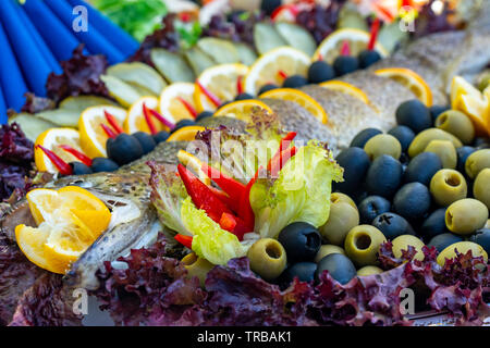 Gegrillte Forelle, Karpfen und Meeräsche. Saftige Köstlichkeit Fisch auf einer Platte mit einem Salat mit gebratenem Gemüse. Balkan Küche. Essen. Stockfoto