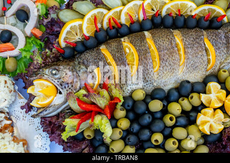 Gegrillte Forelle, Karpfen und Meeräsche. Saftige Köstlichkeit Fisch auf einer Platte mit einem Salat mit gebratenem Gemüse. Balkan Küche. Essen. Stockfoto