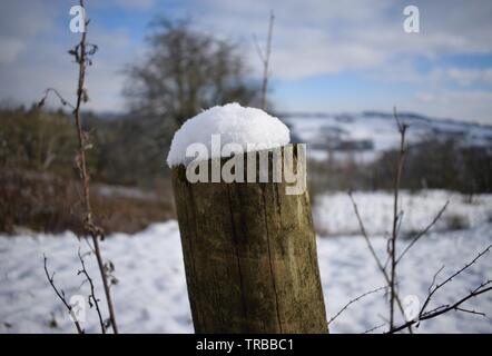 Frischer Schnee auf einem zaunpfosten Stockfoto