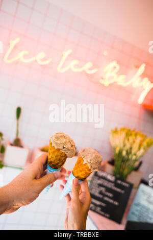 Männliche und weibliche Hände halten Eis in Mad Pops, Bali, Indonesien Stockfoto