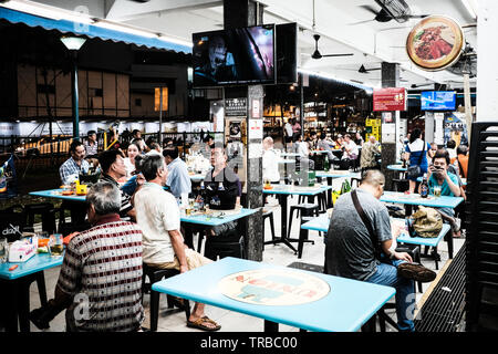 Singaporian Einheimischen in einer Hawker Center bei Nacht, Singapur Stockfoto
