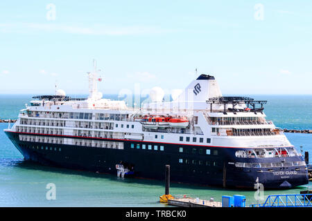 Tagsüber, großen Passagier Kreuzfahrtschiff von kleinen Bootssteg in der Sonne angedockt. Das luxuriöse Kreuzfahrtschiff, "Silver Cloud", durch private Cruise Line betrieben, der ilversea Cruises, angedockt an einen Liegeplatz ausserhalb von Ramsgate Hafen. Das Schiff hat 9 Decks und trägt 300 Passagiere mit einer Crew von 220. Stockfoto