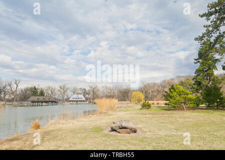 St. Louis Forest Park neben dem Pfosten - Abfertigung See. Rock memorializing ist der See, eine angehende Trauerweide, und das Bootshaus unter teilweise bewölktem Himmel. Stockfoto