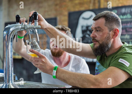 Kiew, Ukraine - 18. MAI 2019: Barkeeper Handwerk Bier in Kiew Beer Festival Vol.4 in der Kunst Zavod Platforma. Mehr als 60 Handwerk Bier Brauereien wurden p Stockfoto