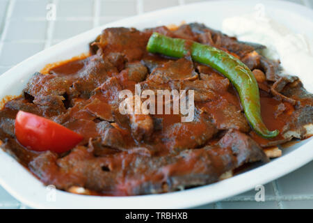 Traditionelle türkische iskender Kebab auf einer hölzernen Oberfläche im Restaurant. Stockfoto