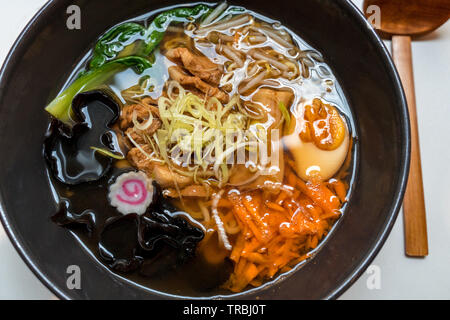 Schüssel mit Schweinebauch japanische Ramen mit Nudeln, frisches Gemüse und gekochtes Ei Stockfoto
